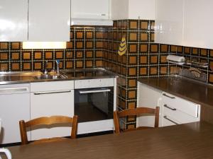une cuisine avec un évier et une table avec des chaises dans l'établissement Apartment Triangel A Leppin by Interhome, à Parpan 12 autres photos