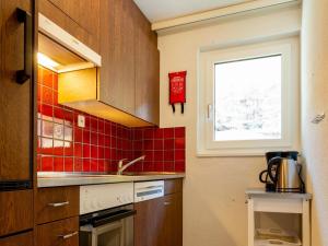 une cuisine avec un évier et du carrelage rouge dans l'établissement Apartment Haus Azur by Interhome, à Saas-Almagell