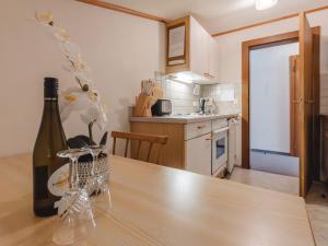 a kitchen with a wooden table with a bottle of wine at Apartment Wildkogel 1 by Interhome in Neukirchen am Großvenediger