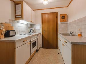 a kitchen with white counters and a wooden door at Apartment Wildkogel 1 by Interhome in Neukirchen am Großvenediger