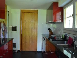 a kitchen with a sink and a wooden door at Apartment Hälmehois by Interhome in Engelberg +8 photos