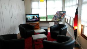 a living room with black chairs and a television at Kyriad Angers Sud Ponts-De-Cé in Les Ponts-de-Cé