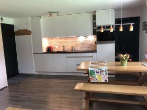Una cocina con gabinetes blancos y una mesa de madera. en Apartment Cresta di Saas by Interhome, en Saas-Grund 11 fotos más