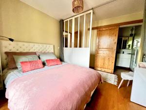 Un dormitorio con una cama grande con dos almohadas rojas. en F3 confort proche Château-CDG-Paris, en Écouen