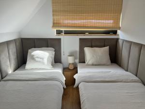 two twin beds in a small room with a lamp at Domki Grabina Boho in Grabina +55 photos