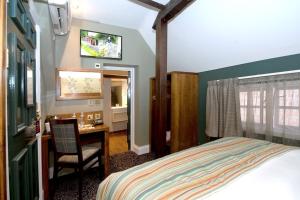 The Hatchet Inn Wetherspoon في نيوبري: غرفة نوم مع سرير ومكتب مع كرسي