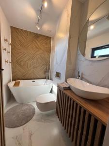 a bathroom with a tub and a toilet and a sink at Domki Grabina in Grabina +17 photos