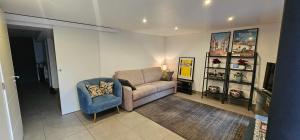 een woonkamer met een bank en een stoel bij Maison Les Vallées in La Garenne-Colombes