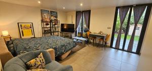 een slaapkamer met een bed en een televisie en een tafel bij Maison Les Vallées in La Garenne-Colombes