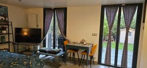 een slaapkamer met een tafel en een kamer met een raam bij Maison Les Vallées in La Garenne-Colombes