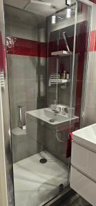 een glazen douche in een badkamer met een wastafel bij Maison Les Vallées in La Garenne-Colombes