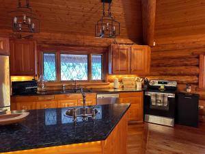 a kitchen with wooden cabinets and a black counter top at Ryders Lodge, Log Home in Edgewater, BC in Radium Hot Springs