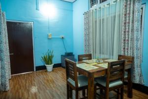 a dining room with a wooden table and chairs at Kangcho Homestay in Diphu
