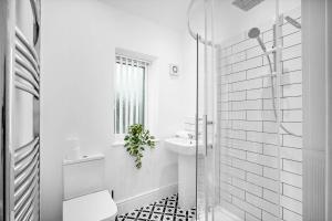 a white bathroom with a sink and a shower at Chic Two Bedroom Apartment - On Street Parking Available - Netflix - Wifi - Top Rated - 311M in Birmingham