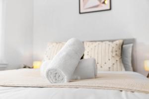 a stack of towels sitting on a bed at Chic Two Bedroom Apartment - On Street Parking Available - Netflix - Wifi - Top Rated - 311M in Birmingham
