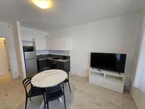 a small living room with a table and a television at Zen Apartments Nazareth in Padova +10 photos