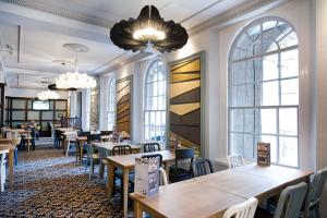 a restaurant with tables and chairs and a chandelier at The Guildhall and Linen Exchange Wetherspoon in Dunfermline