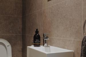 a bottle of alcohol sitting on a sink in a bathroom at One Bedroom Apartment - Carbost - Skye in Carbost +14 photos