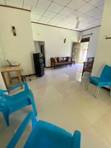 Una sala de estar con sillas azules y un sofá. en Gama villa, en Ahangama 2 fotos más