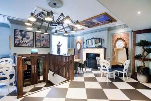 un soggiorno con pavimento a scacchi, tavolo e sedie di The Guildhall and Linen Exchange Wetherspoon a Dunfermline