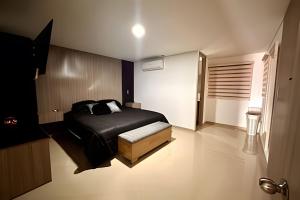 a bedroom with a black bed and a stool at Moderno Apt. Balcón con vista, rápido WiFi y AC in Envigado +44 photos