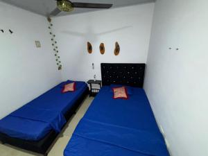 two beds in a room with blue sheets at Apartamento la esmeralda! in Puerto Triunfo