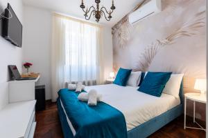 a bedroom with a large bed with blue and white sheets at Fantastic Rome Guest House in Rome