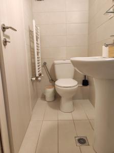a white bathroom with a toilet and a sink at Sea Breeze 101 in Neoi Epivates +13 photos
