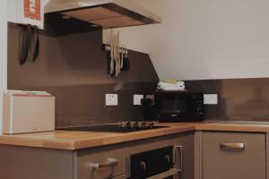 a kitchen with a stove top oven next to a microwave at One Bedroom Apartment - Carbost - Skye in Carbost