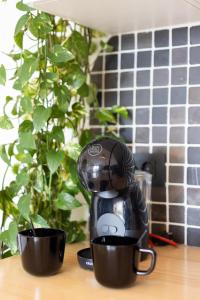 a coffee maker sitting on a table next to two cups at Happy Home by Olax Rentals in Callao Salvaje