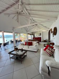 a living room with white couches and a table at Eco Sapê House in Angra dos Reis