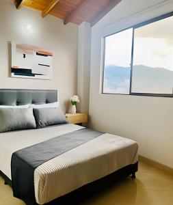 a bedroom with a large bed and a window at beautiful view of the city with local experience in Envigado