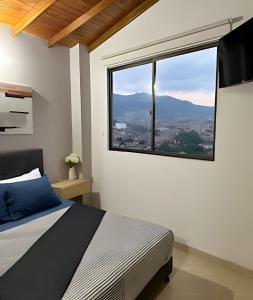 a bedroom with a bed and a large window at beautiful view of the city with local experience in Envigado