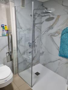 a bathroom with a glass shower with a toilet at Ap Skerup Calpe City cerca Playa in Calpe +36 photos