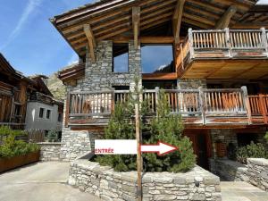 a sign in front of a house with an arrow at Chalet 12 pers, Piscine, Hammam, Proche pistes, Val d'Isère - FR-1-567-129 in Val dʼIsère