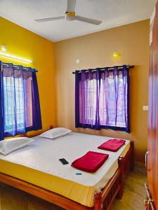 a bedroom with a bed with two red towels on it at Nature Beach Stay in Gokarn