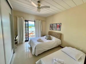a bedroom with a bed and a ceiling fan at Eco Sapê House in Angra dos Reis