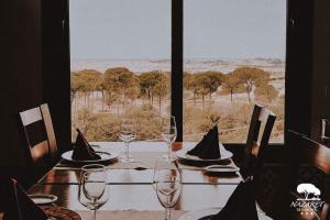 a table with wine glasses and a view of the savannah at Complejo Turístico Rural Nazaret De Moguer in Moguer