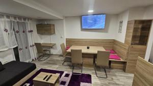 a living room with a table and chairs in a room at App DA-LI SPORT KOPE in Slovenj Gradec