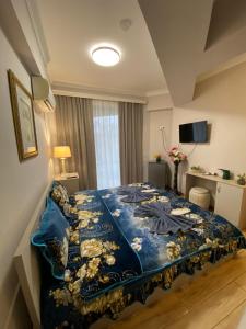 a bedroom with a bed with a blue comforter at Grand Central in Tsqaltubo