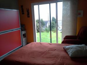 a bedroom with a bed and a large window at kermajo in Plougastel-Daoulas