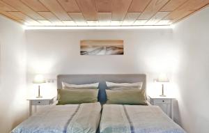 a bedroom with a bed with two lamps on both sides at Ferienhaus Dranske Auf Rügen in Dranske