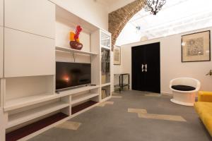 sala de estar con TV y sofá en Enjoy your stay - Navona Square Apt, en Roma