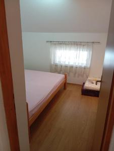 a small bedroom with a bed and a window at Guest house A S S in Sanski most
