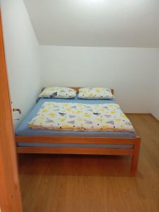a bed in a room with two pillows on it at Guest house A S S in Sanski most