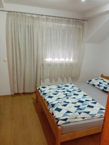 a bedroom with a bed in front of a window at Guest house A S S in Sanski most