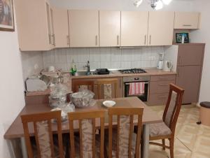 a kitchen with a table and chairs and a stove at Guest house A S S in Sanski most
