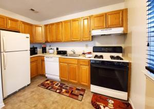une cuisine avec des armoires en bois et un réfrigérateur blanc dans l'établissement Golf view family friendly 3 bed room Bridgewater apt close to Bridgewater Mall, à Bridgewater 10 autres photos