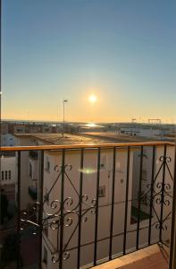 d'un balcon offrant une vue sur le coucher du soleil. dans l'établissement Apartamento Con Vistas A La Bahía, à Puerto Real