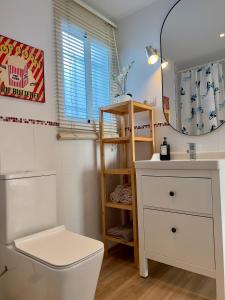 une salle de bain avec toilettes, lavabo et miroir dans l'établissement Apartamento Con Vistas A La Bahía, à Puerto Real